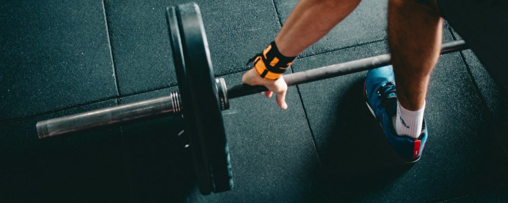 man holding black barbell